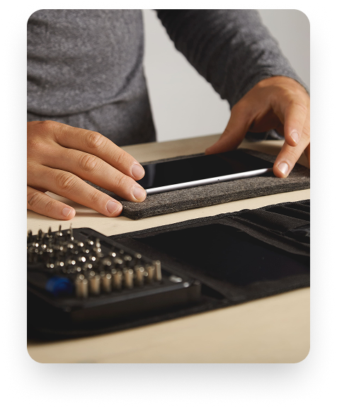 Técnico trabalhando em iPhone com ferramentas de precisão